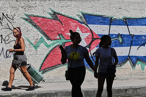 People walk past graffiti in the colors of the Cuban flag in Havana, Cuba, Wednesday, June 17, 2026.