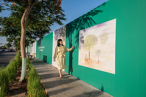 Solimar Miller in front of Flora of Light a series of 12 original artworks celebrating the UAE's indigenous flora and fauna
