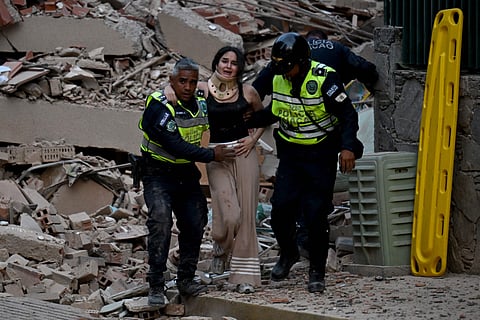 Municipal police officers evacuate an injured victim from a collapsed building following an earthquake in Caracas on June 24, 2026.