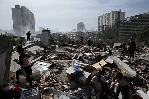 Locals walk amid rubble following a twin earthquake in Caraballeda, La Guaira state, about 40 km northeast of Caracas, on June 25, 2026.