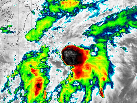 Twin storms force Japan to ground flights and warn of floods, landslides