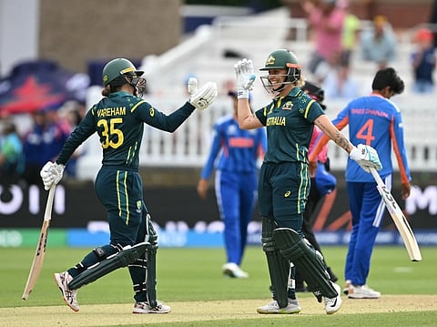 Australia's Georgia Wareham and Australia's Ashleigh Gardner celebrate after beating India