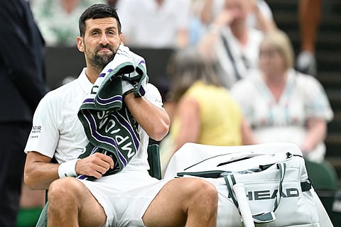 Serbia's Novak Djokovic uses a towel during a break while he plays Greece's Stefanos Tsitsipas during their men's singles second round tennis match on the third day of the 2026 Wimbledon Championships at The All England Lawn Tennis and Croquet Club in Wimbledon, southwest London, on July 1, 2026.