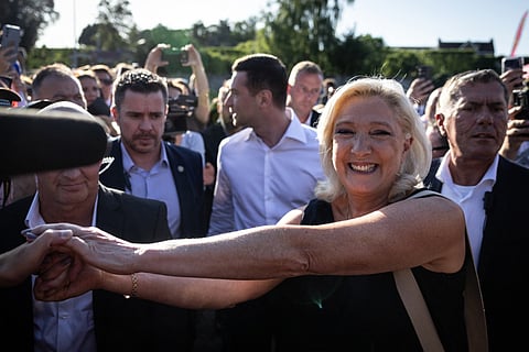 President of Rassemblement National parliamentary group Marine Le Pen shakes hands with a partisan during a RN party event "La fete champetre" in Lievin, northern France on July 4, 2026.