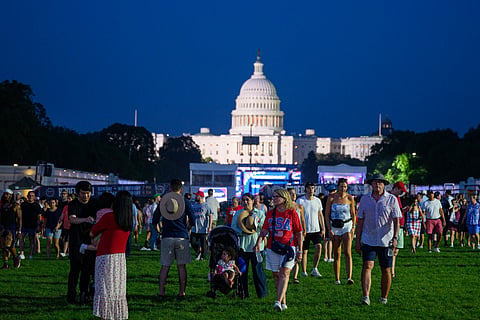 People walk on the grass at the The Great American State Fair after it was reopened following an earlier closure due to extreme temperatures on July 03, 2026 in Washington, DC. The Freedom 250-backed Great American State Fair celebrating the 250th anniversary of the United States closed from around 1PM until 5PM due to high temperatures.