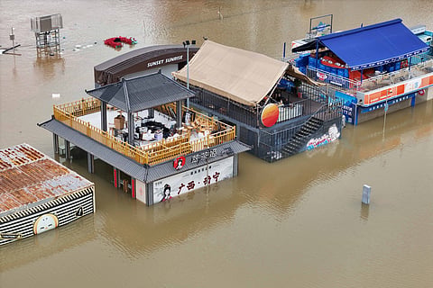 Flooded shops along a submerged riverside walk are seen by the overflowing Yongjiang river in Nanning, in China’s southern Guangxi region.