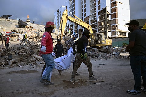 Rescuers carry the body of a victim retrieved from collapsed buildings in Caraballeda, La Guaira state, Venezuela, on July 7, 2026, following the June 24 earthquakes.