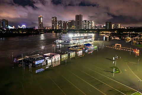 A flooded riverside walkway and shops are seen near a wharf on the Yongjiang river in Nanning, in China’s southern Guangxi region on July 6, 2026.
