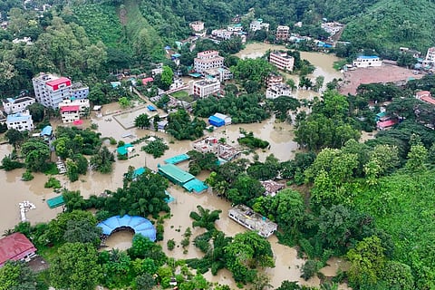 This aerial photograph shows partially submerged residential buildings following heavy rains in Bangladesh's Bandarban town on July 11, 2026.