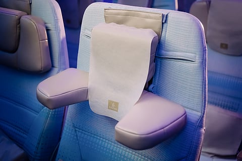 The image shows the world's first U-Dream headrest installed on an Emirates Economy Class seat, highlighting the adjustable side cushions designed to provide personalised neck and head support.