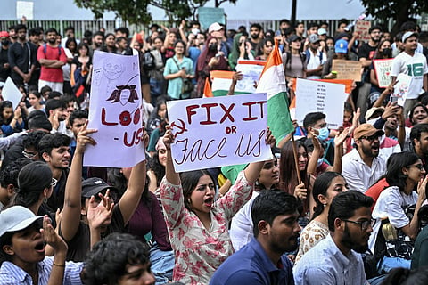 Demonstrators hold placards during a protest in Bengaluru on July 22, 2026 in solidarity with the ongoing protest at New Delhi's Jantar Mantar