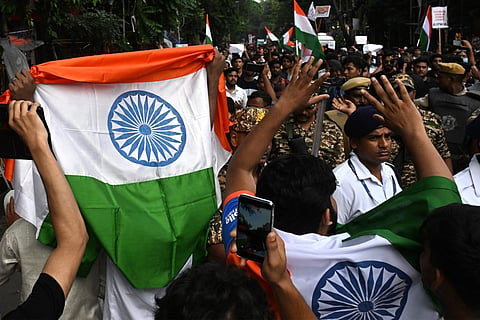 Demonstrators holding Indian national flags take part in a protest rally in Kolkata on July 24, 2026, in solidarity with the ongoing protest by the Cockroach Janta Party (CJP) at New Delhi's Jantar Mantar demanding the resignation of the country's Education Minister Dharmendra Pradhan over alleged NEET examination irregularities.