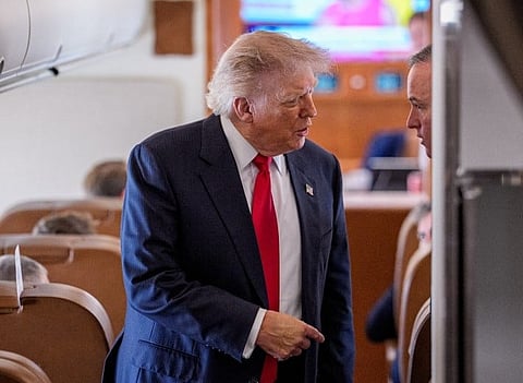 President Donald Trump walks towards members of the media to speak while aboard Air Force One for a trip to Michigan on July 27, 2026 in flight.