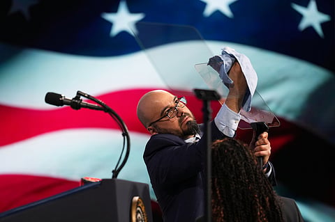 FILE - Gabriel Perez cleans the teleprompter before President Donald Trump speaks at the Future Investment Initiative Institute's summit, March 27, 2026, in Miami Beach, Florida.