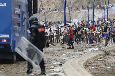 Moroccan security forces clash with migrants attempting to cross into Spain's North African enclave of Ceuta near the town of Fnideq, on the Morocco-Spain border.