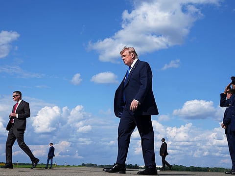 President Donald Trump, center, walks from Air Force One at Morristown Municipal Airport in Morristown, N.J., Friday, July 31, 2026, from Camp David, the presidential retreat. (AP Photo/Jacquelyn Martin)