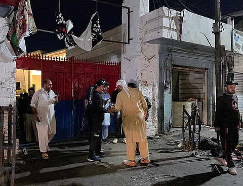 Police officials inspect the site following a suicide bombing during a protest in Pakistan's Swat district.