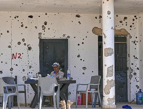 A Lebanese man sits outside his damaged house in the village of Zawtar al-Gharbieh, south Lebanon.