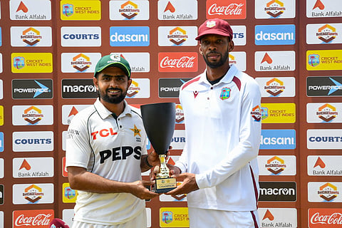 Babar Azam (L) of Pakistan and Roston Chase (R) of West Indies share the trophy for the drawn series at the end of the fourth day of the second Test match between West Indies and Pakistan at Queen's Park Oval in Port of Spain, Trinidad and Tobago, on August 5, 2026.