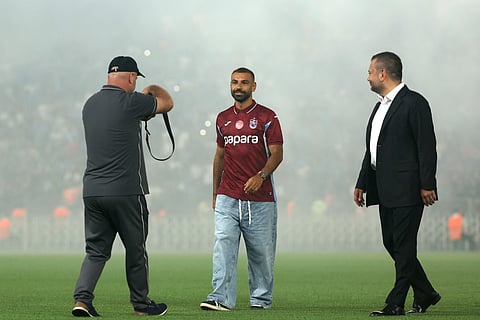 Trabzonspor's Egyptian forward Mohamed Salah (C) walks on the pitch with President of Trabzonspor Ertugrul Dogan (R) during his signing cerenomy at Papara Park Stadium in Trabzon on August 6, 2026.