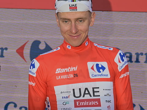 Slovenia's Tadej Pogacar, wearing the overall leader's red jersey celebrates on the podium after the second stage of the La Vuelta cycling race, with start in Monaco and finish in Manosque, France, Sunday, Aug. 23, 2026.