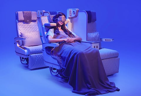 This image shows a customer relaxing in Emirates’ new Premium Economy seat, featuring the globally acclaimed U-Dream headrest by Safran Seats for enhanced neck and head support, alongside an electrically deployable leather footrest and adjustable seating positions.
