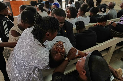 A grieving relative is comforted during a funeral service for victims of a gang attack in the Kenscoff neighborhood of Port-au-Prince, Haiti, Wednesday, Sept. 2, 2026. (AP Photo/Odelyn Joseph)
