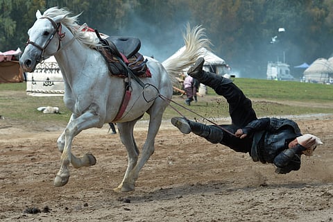 A participant falls while taking part in the horse-riding competition during the World Nomad Games in Kyrchyn Gorge, 240 km (150 miles) southeast of Bishkek, Kyrgyzstan,