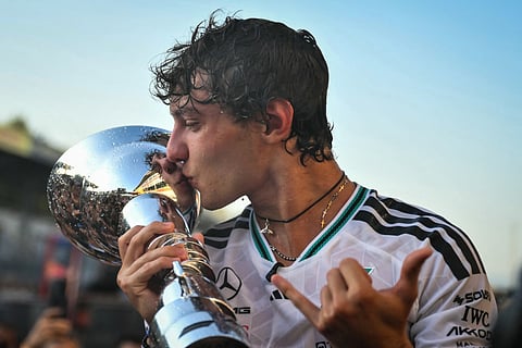 Mercedes' Italian driver Kimi Antonelli kisses the trophy as he celebrates with his team members after winning the Italian Formula One Grand Prix at the Autodromo Nazionale Monza circuit in Monza, northern Italy on September 6, 2026.
