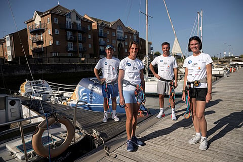 Charlotte Ash (2nd L) and her three adult children Henry Ash (L), James Ash (2nd R) and Camilla Ash (R) pose for a photograph with their rowing boat as they prepare to depart Hartlepool Marina for a practice session before their 3,000-mile (4,828-km) challenge of rowing across the Atlantic Ocean, in Hartlepool, northern England on August 23, 2026.
