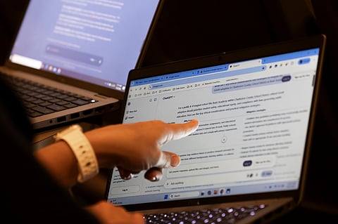 Teachers work with AI on their laptops