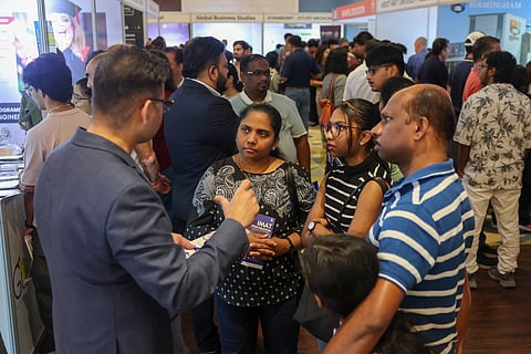 Families discussing study opportunities with exhibitors