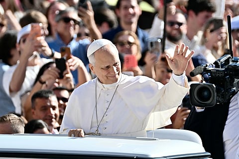 Pope Leo XIV waves to pilgrims as he arrives to lead the weekly general audience at The Vatican
