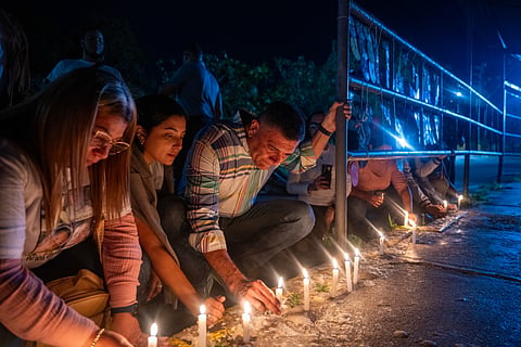 Venezuelan opposition politician and released prisoner Freddy Superlano (C) lights a candle during a vigil to demand the release of political prisoners outside El Rodeo I prison in Guatire, Miranda state, Venezuela on March 2, 2026.