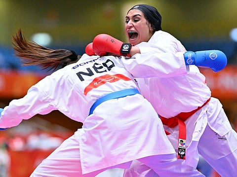 Saudi Arabia's Dina Ahmed Mostafa (R) and Nepal's Arika Gurung compete in the women's kumite +68kg bronze medal karate bout during the 2026 Asian Games at the Toyohashi Gymnasium in Toyohashi, Aichi prefecture on September 20, 2026.