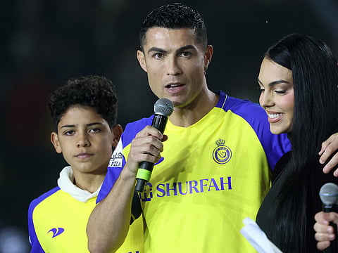 Portuguese forward Cristiano Ronaldo (C-L), accompanied by his partner Georgina Rodriguez (C-R) and his son Cristiano Ronaldo Jr (L), greets the crowd at the Mrsool Park Stadium in the Saudi capital Riyadh