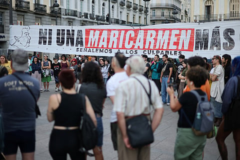 People gather next to a banner reading 'Not a single more Maricarmen' - in reference to an 87-year-old evicted from her Madrid home - as demonstrators camp to protest against evictions and the housing crisis in front of the Presidency of the Community of Madrid on the Puerta del Sol plaza in Madrid on September 27, 2026.