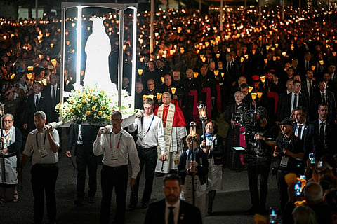 Pope Leo XIV (C) takes part in a torchlight procession following the Rosary Prayer at the Shrine of Our Lady of Lourdes, southwestern France, on September 27, 2026 on the third day of his visit to France.