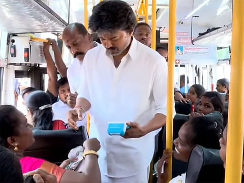 Tamil Nadu Chief Minister C. Joseph Vijay hands out tickets to women passengers as part of an expansion of the state's free bus travel scheme.