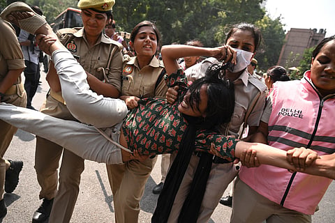 Police personnel detain a supporter of the Cockroach Janata Party (CJP) during a protest demanding the resignation of India’s Chief Election Commissioner Gyanesh Kumar over alleged voter roll irregularities linked to the "special intensive revision" (SIR), in New Delhi on October 10, 2026.
