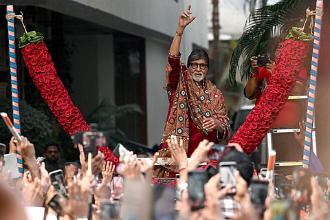 Bollywood actor Amitabh Bachchan gestures to fans gathered to celebrate his 84th birthday outside his residence in Mumbai on October 11, 2026.