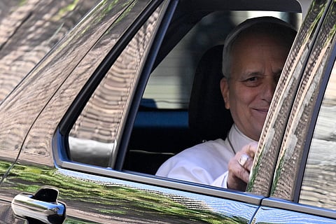 Pope Leo XIV waves from the window of the car as he leaves the Vatican before being admitted to Rome's Gemelli University Hospital for an operation to remove a lump from his lung, in the Vatican on 13 October 2026.