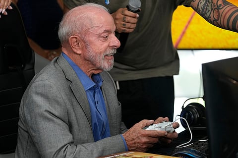 Brazilian President Luiz Inacio Lula da Silva, who is running for reelection, plays a Brazilian video game before a ceremony to sign a decree regulating the video game industry in Brasilia, Brazil, Wednesday, Oct. 14, 2026. (AP Photo/Eraldo Peres)