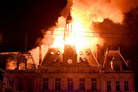 This photograph shows a fire burning and destroying the city hall after a group of individuals forced entry into the building during ongoing protest action against the "high cost of living", in Limoges, central France on October 17, 2026 as part of a nationwide call for mobilisation bringing together various groups expressing their anger: former "Yellow Vest", secondary school and university students, climate activists and even farmers.