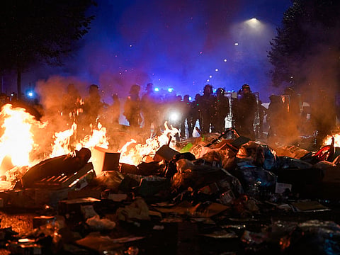 Police officers stand behind a fire near Place de la Republique following an unauthorised demonstration, central Paris.