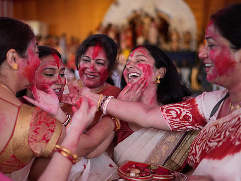 Women apply sindoor, or vermilion powder, to each other’s faces during Sindoor Khela on the final day of Durga Puja celebrations in Hyderabad, India. The traditional ritual, observed by married women, marks the farewell to Goddess Durga before her idols are immersed, symbolising devotion, prosperity and marital happiness.