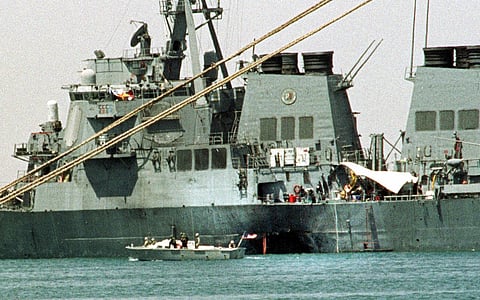 FILE - A small boat guards the stricken USS Cole in Aden, Yemen, Oct. 20, 2000. (AP Photo/Hasan Jamali, File)