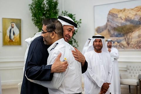 This handout picture provided by the UAE Presidential Court shows UAE President Sheikh Mohamed bin Zayed Al-Nahyan embracing Flydubai pilot Smit Machchhar, during a reception for him and other crew members of Flight 1073 in Abu Dhabi on October 27, 2026.