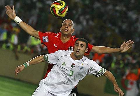 Egyptian soccer player Wael Gomaa and Algerian Abdelkader Ghezzal, front, challenges for the ball.