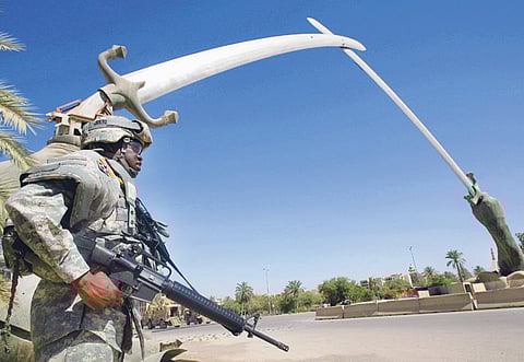 A file picture of a US soldier standing quard in front of the Hands of Victory arch in Baghdad's Green Zone.